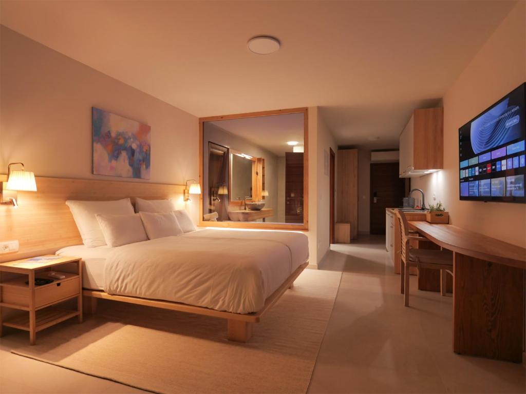 Romanticly lightened bedroom with a double bed and wall television