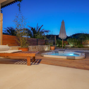 View of outside jacuzzi in sunset from lighted terrace