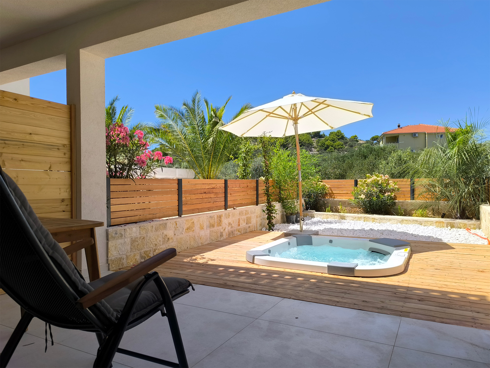 View of outside jacuzzi from shadow covered terrace