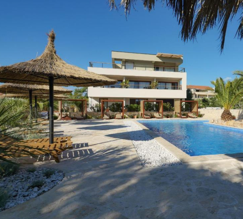 View of Villa Lojena from the outside from the outside during daytime with Pool and Palms