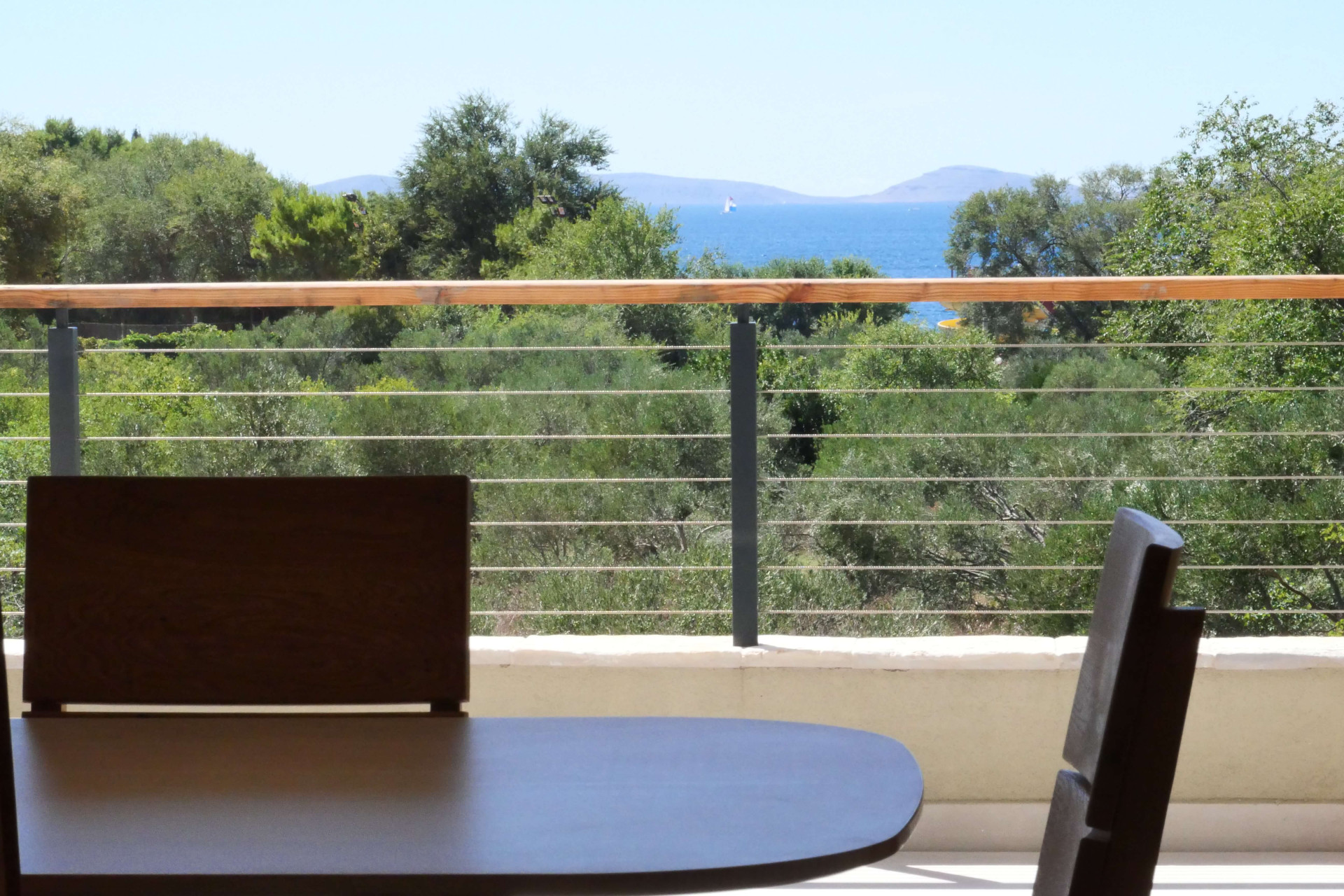 View of the sea and trees from balcony table