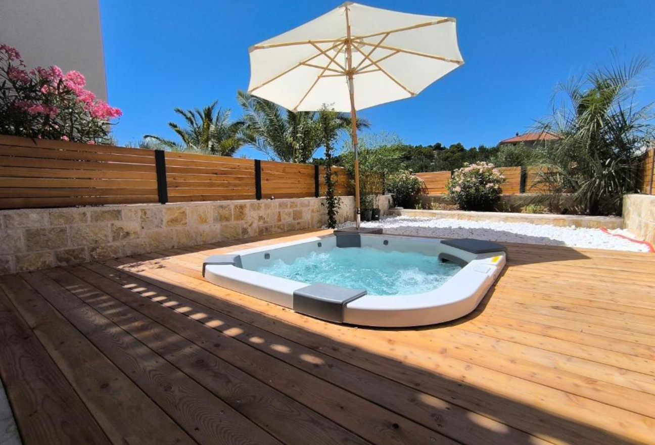 Outdoor jacuzzi in the shade of a parasol